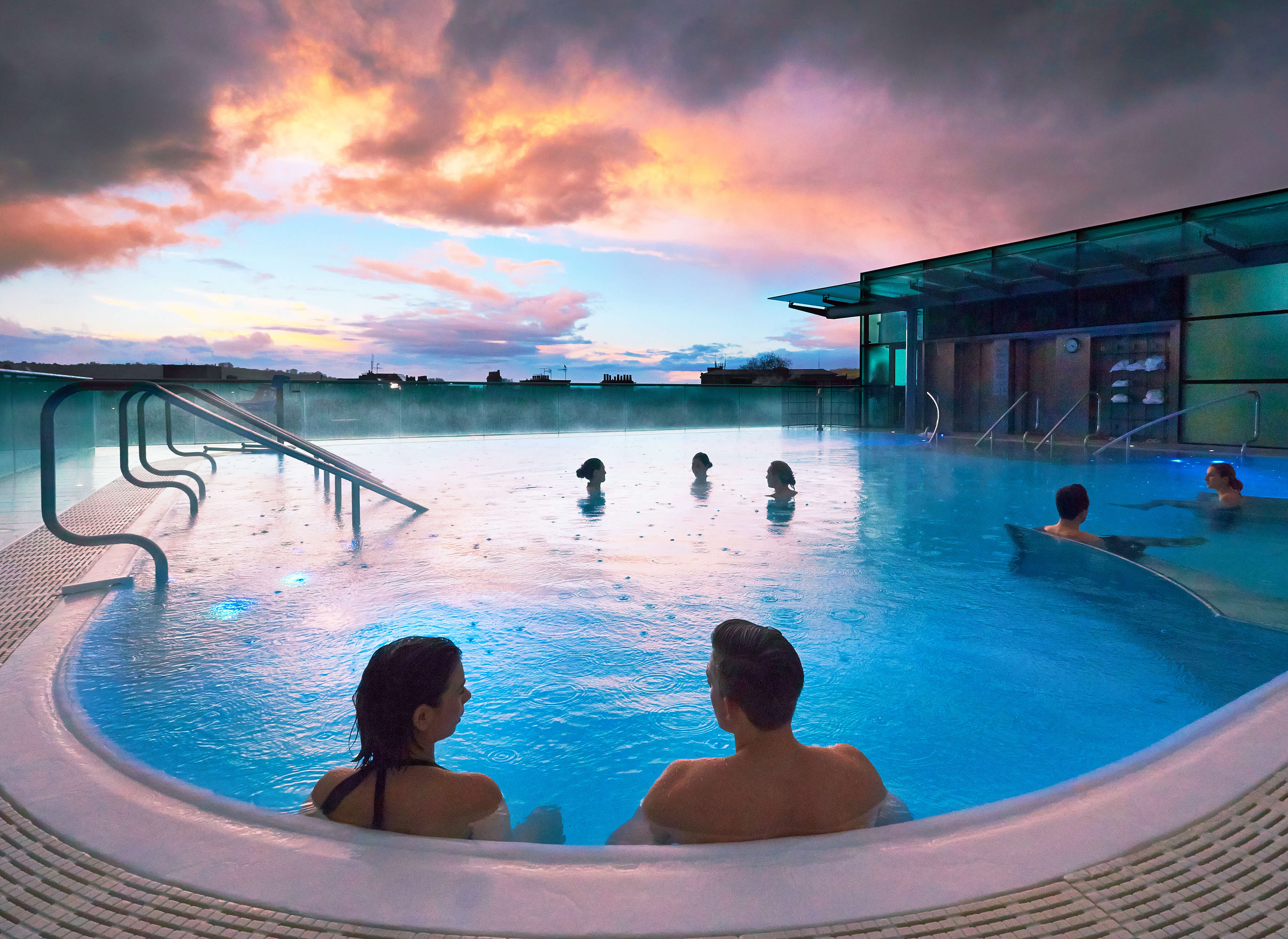 Guests relaxing in the rooftop pool at Thermae Bath Spa in Bath
