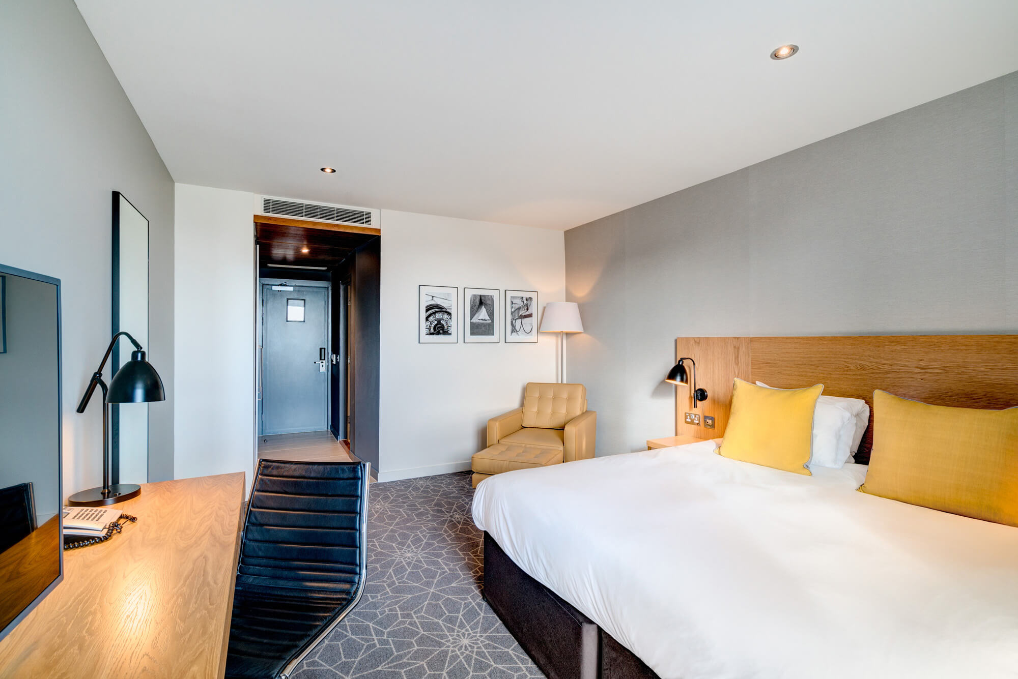 King-size bed with armchair and desk with TV